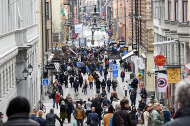 People gather near the crime scene in central Stockholm April 8, 2017, the day after a hijacked beer truck plowed into pedestrians on Drottninggatan and crashed into Ahlens department store. (Reuters)