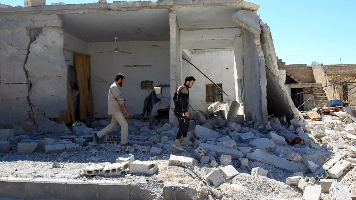 Civil defense members inspect the damage at a site hit by airstrikes on Tuesday, in the town of Khan Sheikhoun in rebel-held Idlib. (Reuters)
