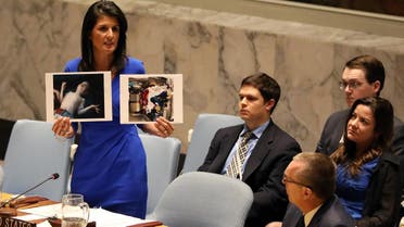 US Ambassador to the UN Nikki Haley holds photographs of victims during a meeting at the Security Council on Syria in New York on April 5, 2017. (Reuters)