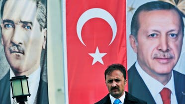 In this photo taken on Monday April 3, 2017, a member of security for Erdogan stands guard next to banners showing modern Turkey's founder Mustafa Kemal Ataturk, left, and Turkey's current President Recep Tayyip Erdogan, right, following his speech at a rally in his hometown Black Sea city of Rize, Turkey. ap