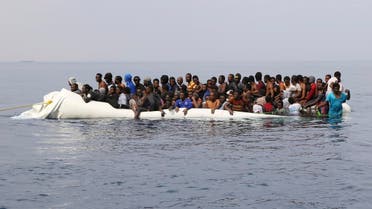 Migrants wait to be rescued from a sinking dingey off the Libyan coasal town of Zawiyah, east of the capital, on March 20, 2017, as they attempted to cross from the Mediterranean to Europe. (AFP)