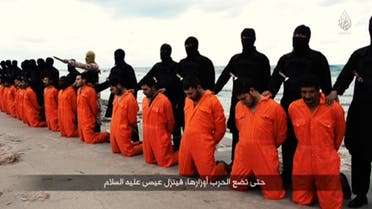 Men in orange jumpsuits purported to be Egyptian Christians held captive by the Islamic State (IS) kneel in front of armed men along a beach said to be near Tripoli, in this still image from an undated video made available on social media on February 15, 2015. reuters