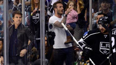 Actor Tom Cruise, left, and David Beckham, holding his daughter Harper, watch the NHL hockey Stanley Cup playoffs in Los Angeles on May 28, 2013. (AP)