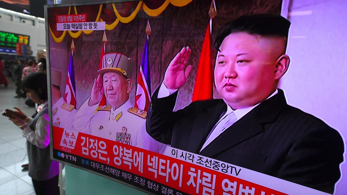 People watch a television news broadcasting live footage of a parade to mark the 105th anniversary of the birth of North Korea's founder Kim Il-Sung, at a railway station in Seoul on April 15, 2017.