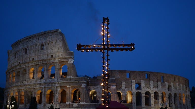 A cross is illuminated at the Colosseum prior the Via Crucis (Way of the Cross) torchlight procession on Good Friday, on April 14, 2017 in Rome. (AFP)