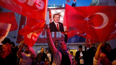 Supporters of Justice and Development party (AK) wave Turkish flags and hold a poster of Turkish President Recep Tayyip Erdogan outside its offices in Istanbul, Sunday, April 16, 2017. (AP)