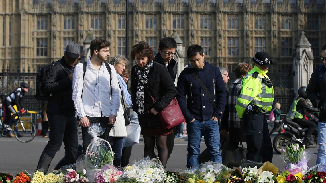 People view floral tributes to victims of attack outside the Houses of Parliament in London on March 24, 2017. (AP)