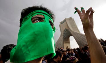 A demonstrator wears a mask in the party's color of green, due to fears of being identified, as hundreds of thousands of supporters of leading opposition presidential candidate Mir Hossein Mousavi turned out to protest the result of the 2009 election at a mass rally in Azadi (Freedom) square in Tehran, Iran. (File photo: AP)