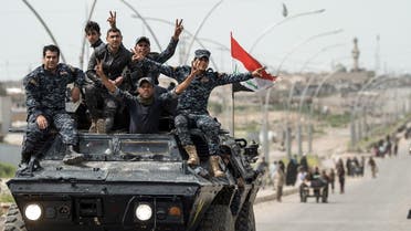 Members of the Iraqi federal police flash the victory gesture as they sit on an armoured personnel carrier (APC) on a road in west Mosul on April 21, 2017. (AFP)