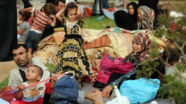 Syrian nationals fleeing the conflict in their home country gather in a garden in Port Said Square in Algiers on July 28, 2012. AFP PHOTO/FAROUK BATICHE