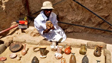 A member of an Egyptian archaeological team shows artifacts discovered in a 3,500-year-old tomb in the Draa Abul Nagaa necropolis, near the southern city of Luxor, on April 18, 2017. (AFP)