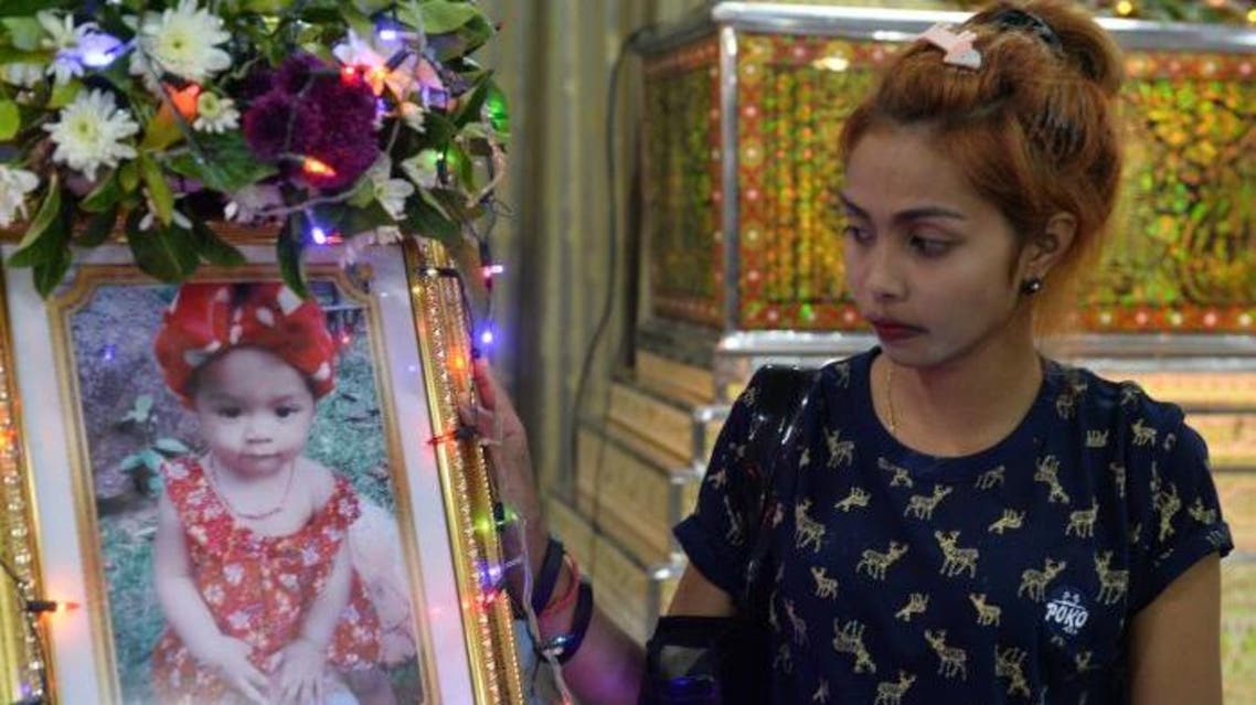 Jiranuch Trirat, mother of 11-month-old daughter who was killed by her father who broadcast the murder on Facebook, stands next to a picture of her daughter at a temple in Phuket, Thailand April 25, 2017. (Reuters)