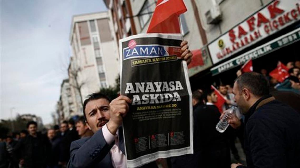 A man holds the copy of Zaman newspaper outside the headquarters of Zaman newspaper in Istanbul, on March 6, 2016. (AP)