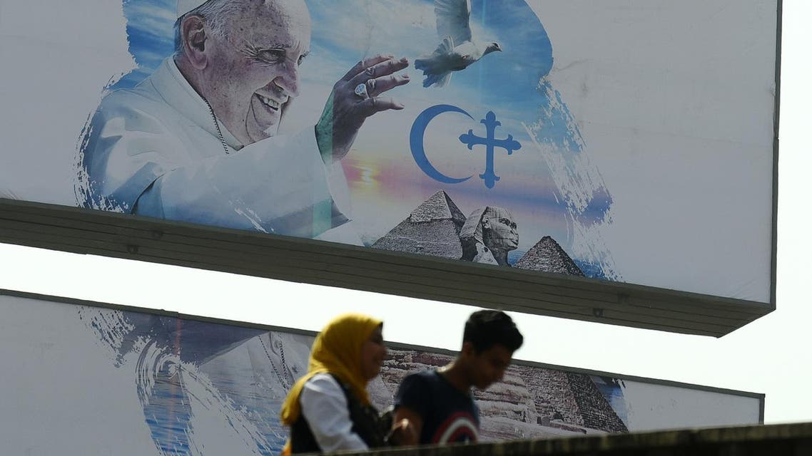 Egyptians walk past a welcome banner bearing a portrait of Pope Francis a day ahead of his visit to the capital Cairo, on April 27, 2017. (AFP)
