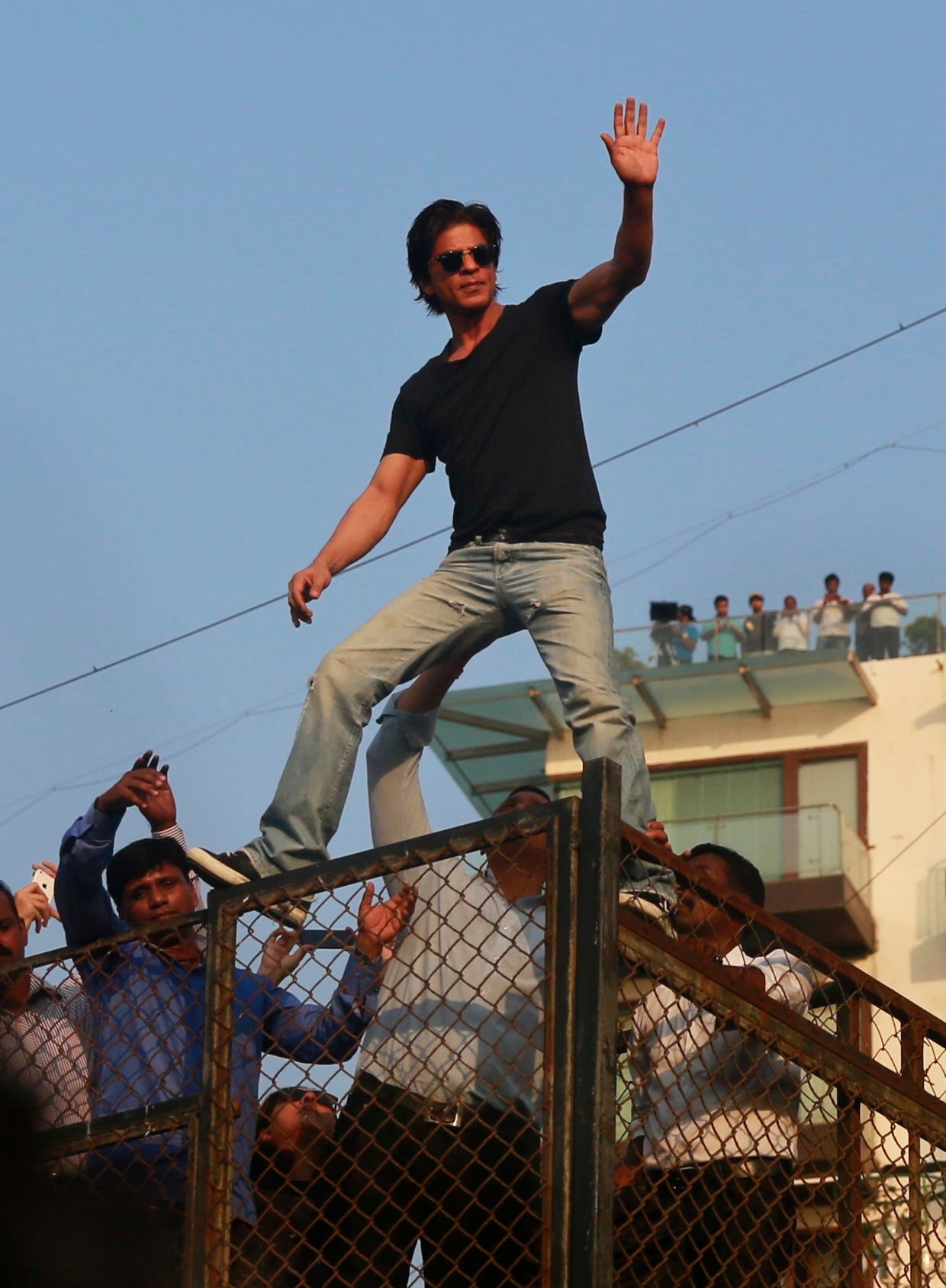 Shahrukh Khan climbs on to a wall of his house to greet his fans who gathered to wish him on his birthday in Mumbai, India, on Nov. 2, 2014. (AP)