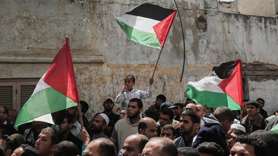 Supporters of the Palestinian Hamas movement wave national flags during a protest against the Israeli blockade of the Gaza Strip on April 14, 2017, in Khan Yunis. (AFP)