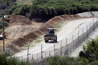 A general view taken from the Lebanese side of the border with Israel shows an Israeli bulldozer driving as they erect new fortifications near the Israeli kibbutz of Hanita on April 20, 2017. (AFP)