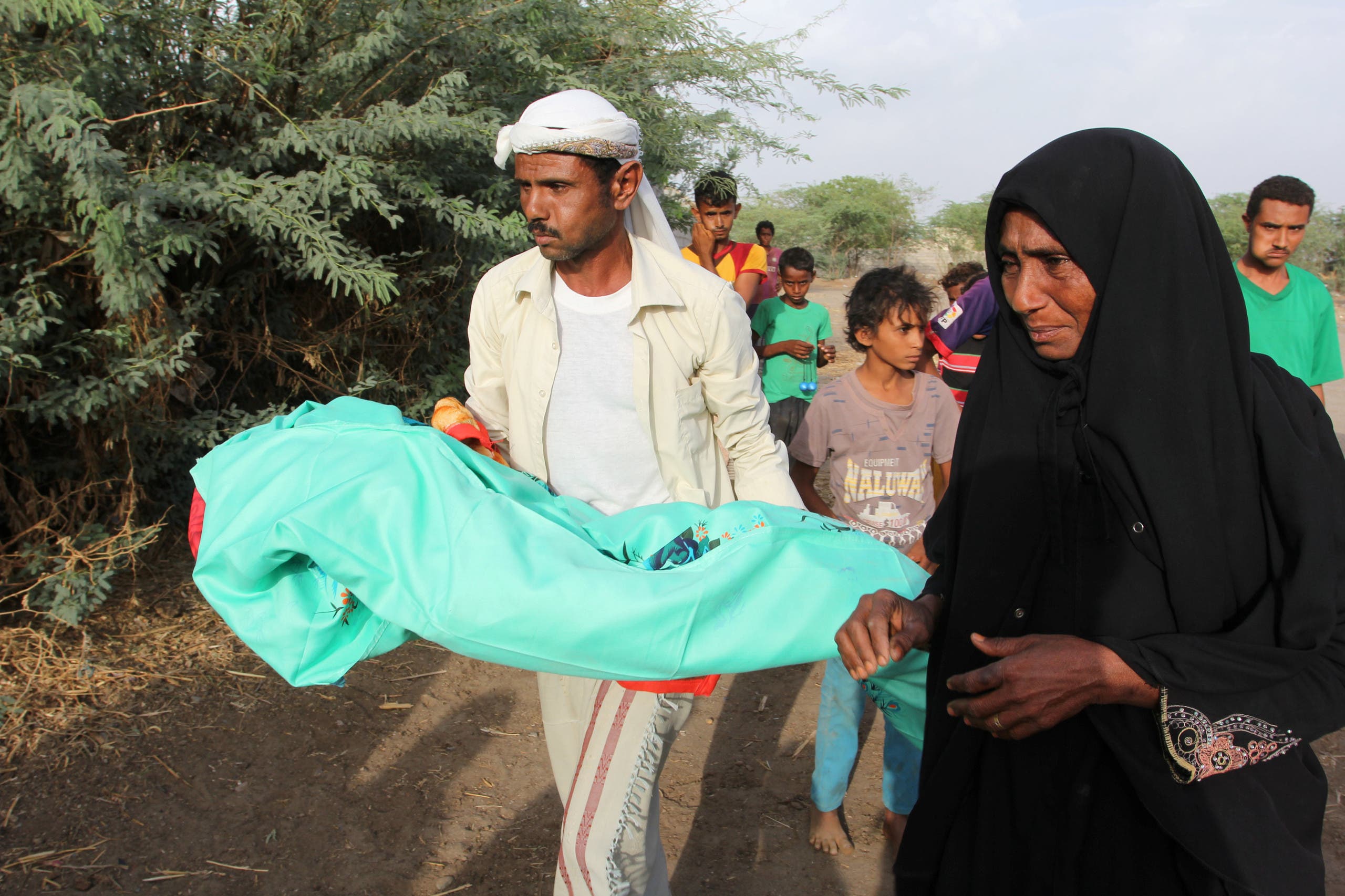 A relative of Jamila Ali Abdu, 7, carries her body to a burial procession in a village graveyard following her death of malnutrition in the Red Sea port city of Hodeidah, Yemen May 2, 2017. (Reuters)