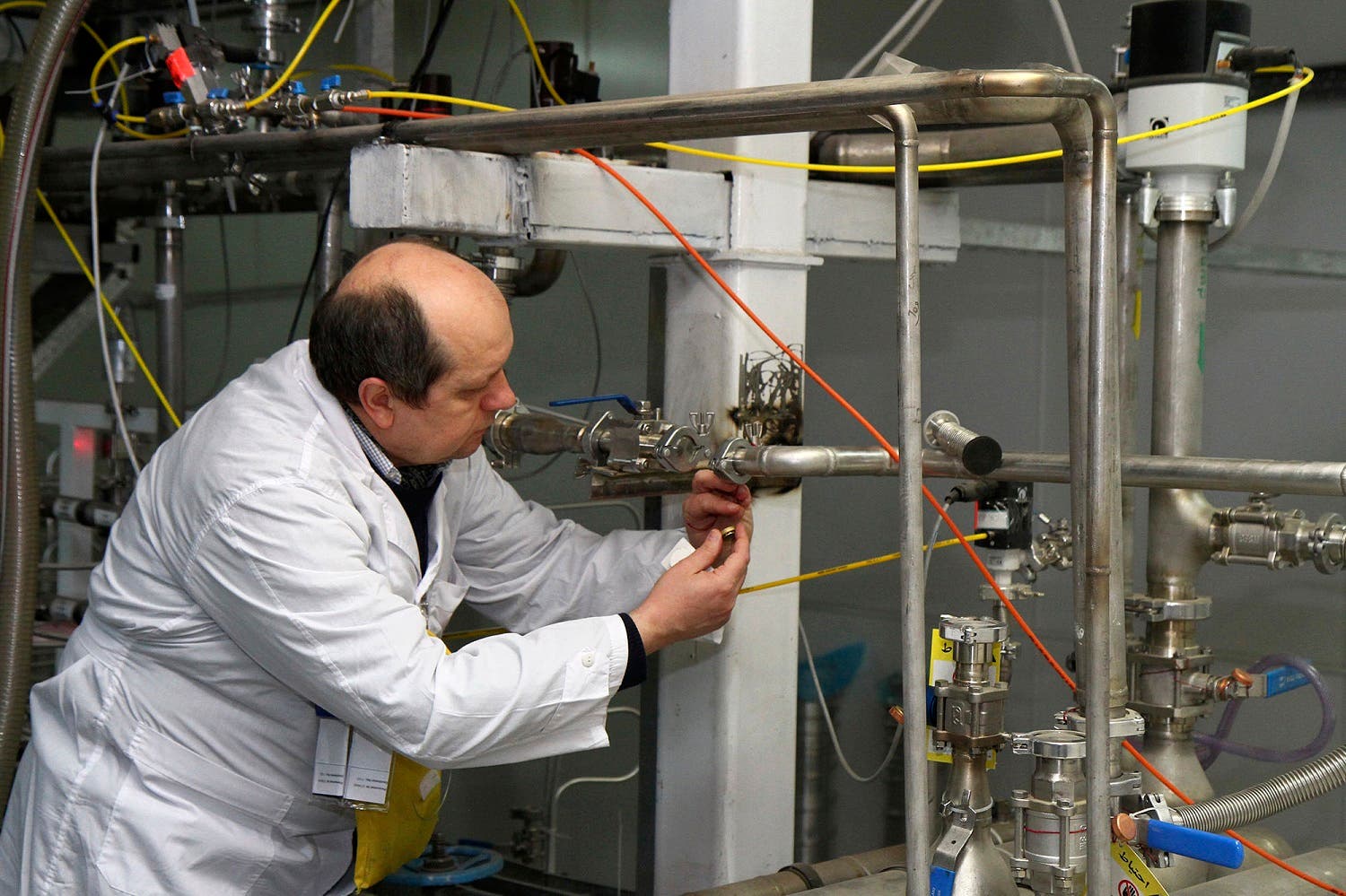 An unidentified IAEA inspector cuts the connections between the twin cascades for 20 percent uranium enrichment at the Natanz facility, some 322 kilometers south of Tehran on Jan. 20, 2014. (AP)
