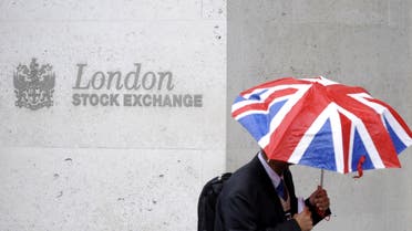 A worker shelters from the rain under a Union Flag umbrella as he passes the London Stock Exchange in London, Britain, October 1, 2008. reuters