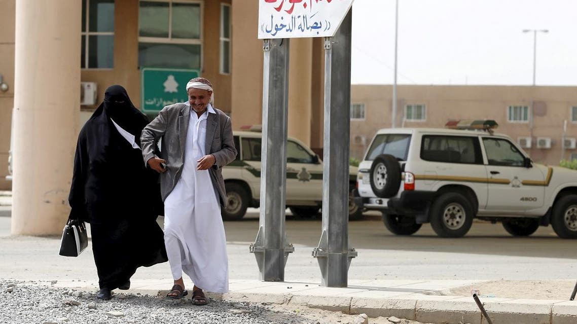A Yemeni man walks with his wife as they arrive to stamp their passports to enter Saudi Arabia at Al-Tiwal crossing in Jizan on Saudi Arabia's border with Yemen, April 7, 2015. (Reuters)