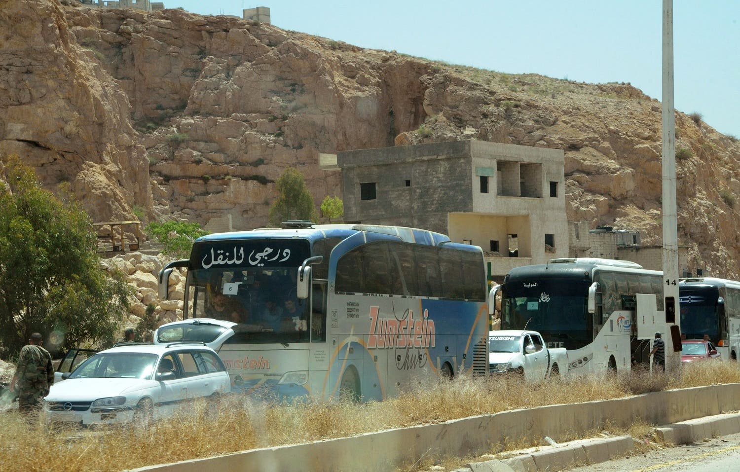 A handout picture released by the Syrian Arab News Agency (SANA) on May 8, 2017, shows the first batch of militants and some of their family members leaving from Damascus' Barzeh neighbourhood following a deal to evacuate the area. Syrian rebels and their families began evacuating from a district of Damascus for the first time on Monday, bringing the government closer to recapturing all of the capital. (AFP)