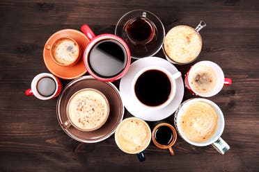 Many cups of coffee are placed on a wooden table. (Stock image)