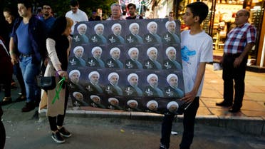 Supporters of Iranian President and election candidate Hassan Rouhani distribute brochures ahead of the Iranian presidential election in the streets of the capital Tehran. (AFP)