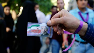 A supporter of Iranian President and election candidate Hassan Rouhani distributes brochures ahead of the Iranian presidential election in the streets of the capital Tehran on May 17, 2017. (AFP)