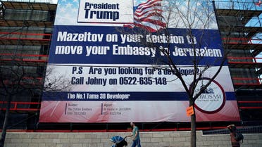 People walk past a giant banner on a building congratulating US President-elect Donald Trump, in Jerusalem, January 20, 2017. (Reuters)