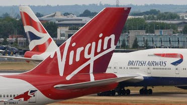 A British Airways 747 passes the tail fin of a Virgin Atlantic plane at Heathrow Airport, London. (File photo: AP)