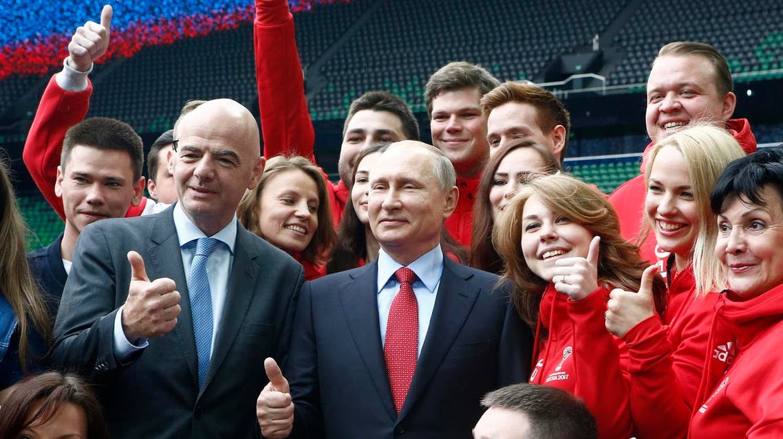 Russian President Vladimir Putin (C) and FIFA President Gianni Infantino pose for a picture with members of Russia's volunteer associations at the FC Krasnodar Stadium in the southern city of Krasnodar on May 23, 2017. (AFP)