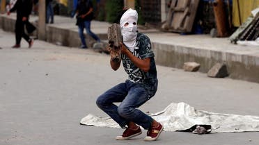 A masked protester prepares to throw a rock towards the Indian police during a protest after Friday prayers, in Srinagar, May 26, 2017. (Reuters)