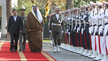 Former Iranian President Mahmoud Ahmadinejad (L) and Former Qatari Emir Sheikh Hamad Bin Khalifa al-Thani inspect the honor guard during a welcoming ceremony prior to their meeting in Tehran in 2010. (AFP)