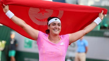 Ons Jabeur holds up Tunisian flag after winning against Slovakia’s Dominika Cibulkova at the Roland Garros 2017 on May 31, 2017. (AFP)