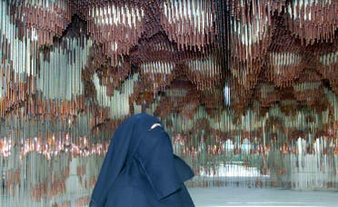 A woman looks at a rope and cooper life-size reproduction of the ceiling of the Palatine Chapel in Palermo (sec XII, designed by Muslim craftsmen for King Ruggero II, at “Islam in Sicily” exhibition on July 11, 2002. (Reuters)