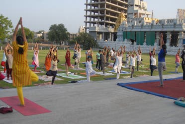 Woman instructors leading yoga exercises with a group of people. (Supplied)