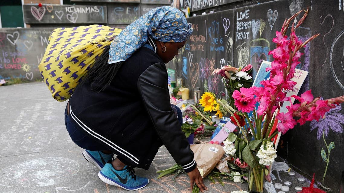 Muslim woman, who preferred not to giver her name, prays at a makeshift memorial. (Reuters)