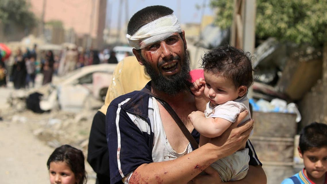 ATTENTION EDITORS - VISUAL COVERAGE OF SCENES OF INJURY OR DEATH A wounded displaced Iraqi man who fled from clashes, carries his child in western Mosul, Iraq, June 3, 2017. REUTERS/Alaa Al-Marjani TPX IMAGES OF THE DAY