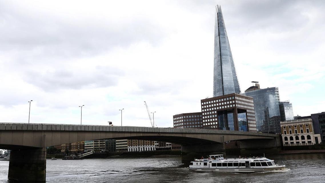 A tourist boat travels along the River Thames under London Bridge in London. (Reuters)