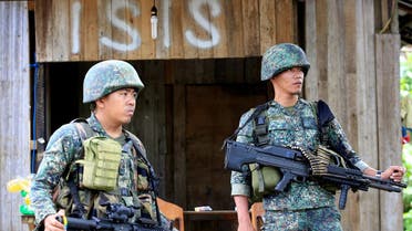 Soldiers stand guard along the main street of Mapandi village as government troops continue their assault on insurgents from the Maute group, who took over large parts of Marawi City, Philippines. (Reuters)