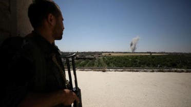 A Syrian Democratic Forces fighter watches smoke billowing from al-Mashlaab district in Raqqa. (Reuters)