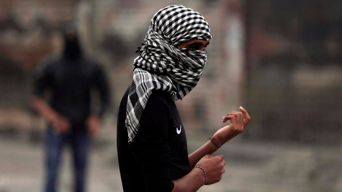 FILE - In this Monday, March 14, 2016 photo, a Bahraini anti-government protester watches for riot police during clashes in Daih, Bahrain. Bahraini police detained a political activist and her year-old son on Monday in an operation that came on the fifth anniversary of Saudi and Emirati soldiers putting down Arab Spring-inspired protests in the tiny island kingdom. (AP Photo/Hasan Jamali, File)