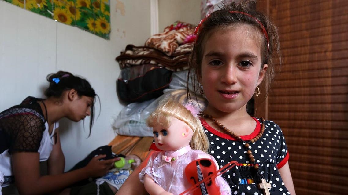 Christina, a six-year-old Iraqi Christian girl, holds a doll during a meeting with her family in Ashti 2 camp for displaced Christians in Arbil, the capital of the autonomous Kurdish region of northern Iraq on June 10, 2017. (AFP)