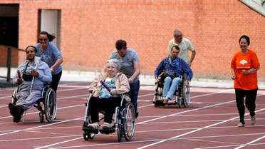 A participant is pushed by an assistant as they take part in the 4x25 metres relay during the "Olympics for Seniors" event at King Baudouin stadium in Brussels, Belgium June 13, 2017