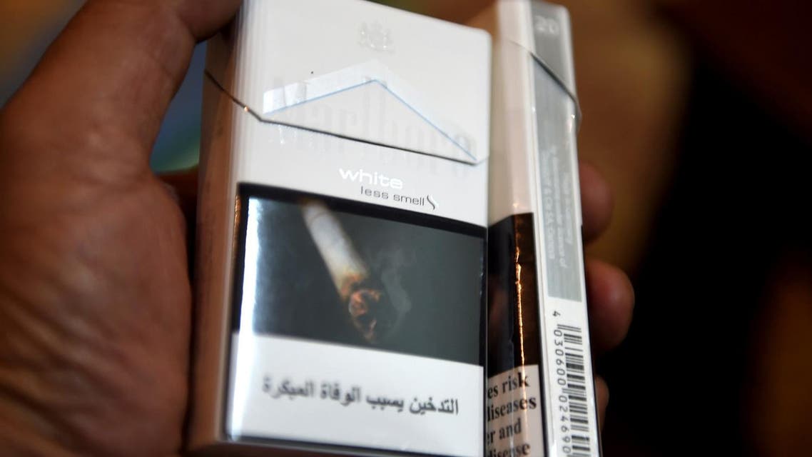 A man displays a pack of cigarettes outside a tobacco shop in Riyadh on June 11, 2017. (AFP)