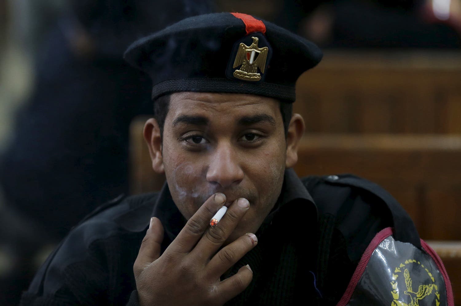 A policeman smokes cigarette in Cairo on April 11, 2015. (Reuters)