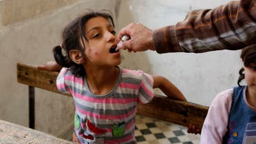 An activist health worker administers a polio vaccination to a child in Aleppo May 4, 2014. REUTERS/Hosam Katan (SYRIA - Tags: POLITICS CIVIL UNREST CONFLICT HEALTH)