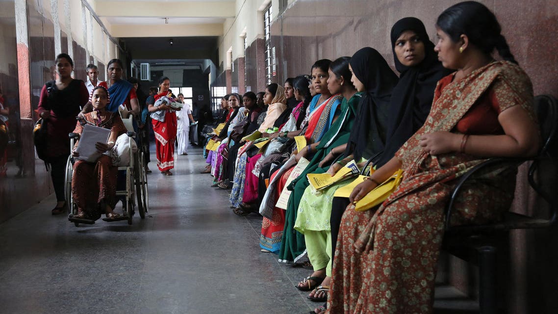 Pregnant Indian women hold their medical cards and wait for their turn to be examined at a government hospital on World Population Day in Hyderabad, India, Friday, July 11, 2014.(AP)