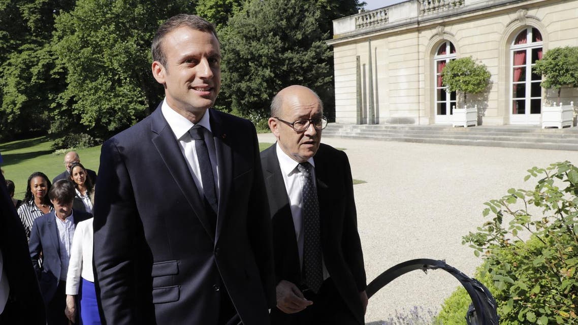 French president Emmanuel Macron (L) leaves with French Foreign Affairs Minister Jean-Yves Le Drian for a cabinet meeting after they posed for a family photo at the Elysee Palace in Paris on June 22, 2017. (AFP)